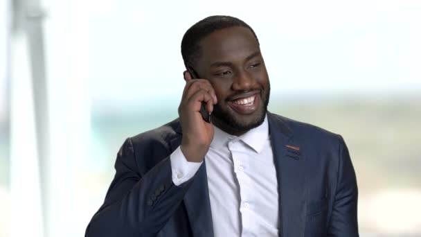 Zwarte lachende zakenman praten over telefoon. — Stockvideo