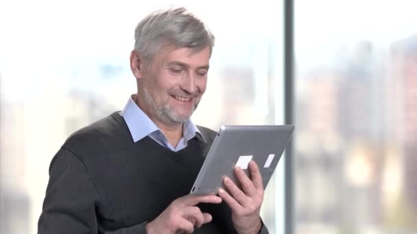 Χαμογελώντας ώριμος άνδρας χρησιμοποιώντας ψηφιακό tablet. — Αρχείο Βίντεο