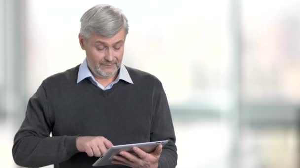 Handsome man using digital tablet on blurred background. — Stock Video