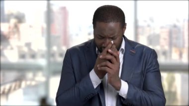 Afro-Amerikan işadamı üzerinde arka plan bulanık ağlıyor. İş kıyafeti koyu renkli stresli erkekte ağlıyor. Siyah girişimci için dua ediyor.