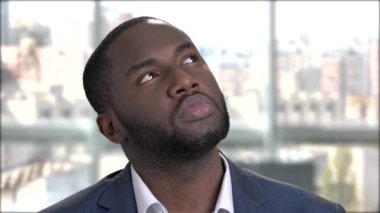 Düşünceli Afro-Amerikan işadamı gülümsüyor.