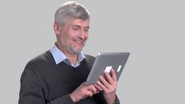 Gülümseyen beyaz adam dijital tablet kullanma.