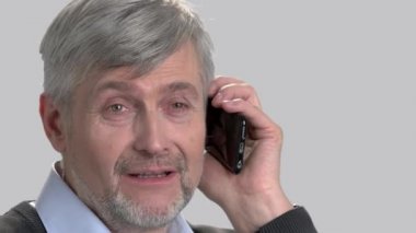 Gülümseyen adamın cep telefonuyla konuşurken yüzünü.