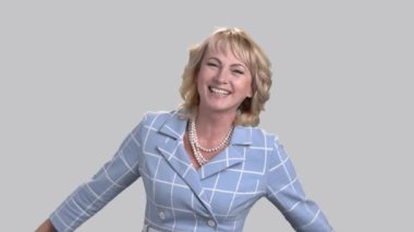 Neşeli kadın gri arka plan üzerinde gülüyor.