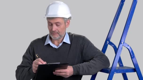 Portrait of caucasian foreman writing on clipboard. — Stock Video