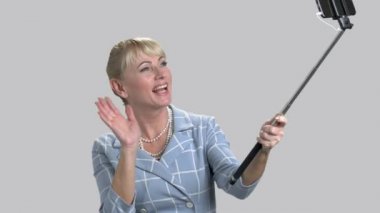 Monopod tutarak ve el sallayarak kadın.