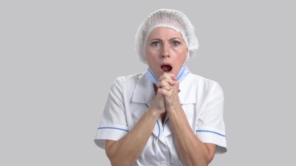 Asustada mujer horrorizada médico sobre fondo gris . — Vídeo de stock