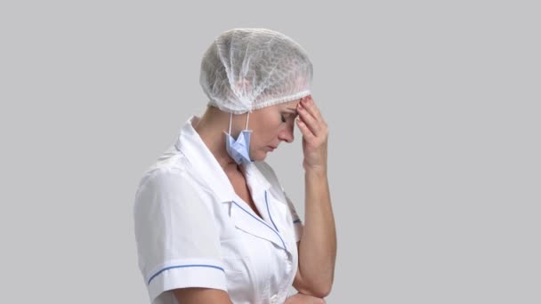 Médico femenino estresado sobre fondo gris . — Vídeo de stock