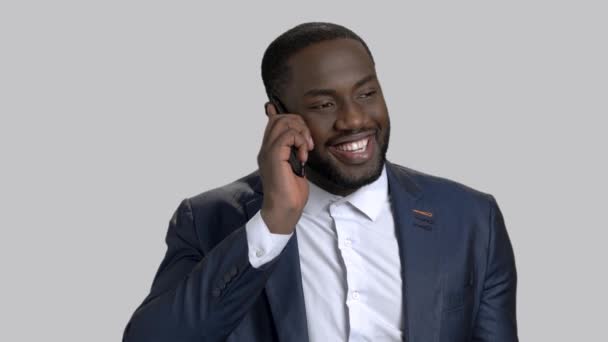 Lachende zakenman via telefoon op grijze achtergrond. — Stockvideo