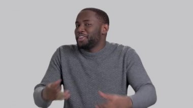 Gri arka plan üzerinde neşeli Afro-Amerikan adam.