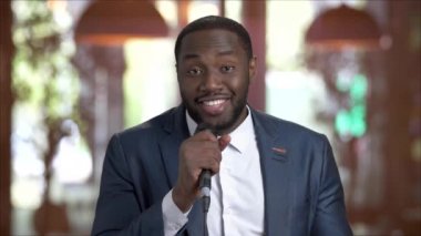 Afro-Amerikan adam mikrofon ile şarkı söylüyor.