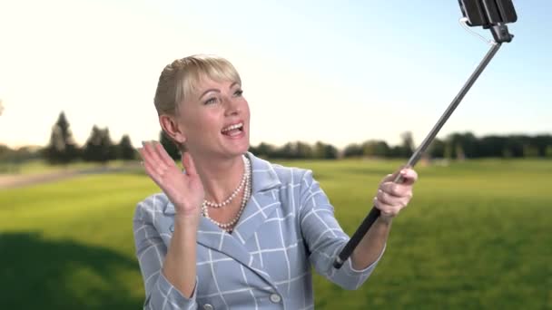 Woman holding monopod and waving with hand. — Stock Video
