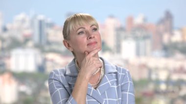 Gülümseyen düşünme kadın üzerinde arka plan bulanık.