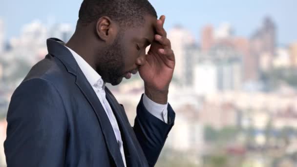 Tired afro-american businessman on blurred background. — Stock Video