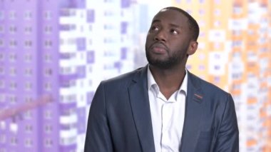 Arka plan bulanık üzerinde düşünceli Afro-Amerikan işadamı.