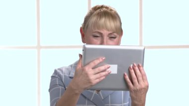 Damalı pencere arka plan üzerinde dijital tablet kadınla.