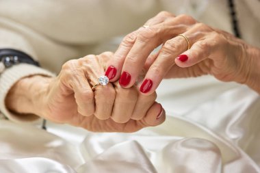 Yaşlı kadın elmas parmağına dokunmak.