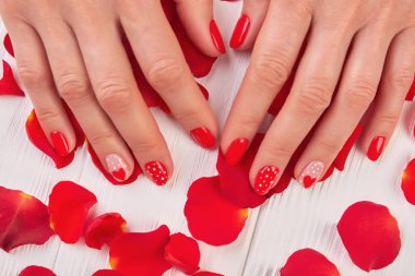 Erkek elleri manikürlü ve gül yaprakları.