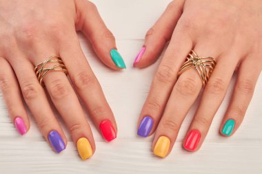 Manikürlü eller lüks yüzük. Genç kadın elle yaz renkli manikür pahalı altın mücevher takıyor. Güzellik ve moda oncept.