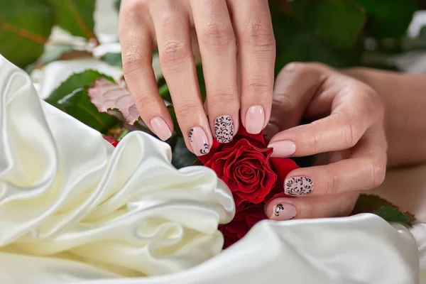 Manos femeninas sosteniendo rosas rojas . — Foto de Stock