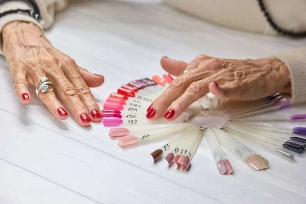 Зрелая женщина руки с красными ногтями . — стоковое фото