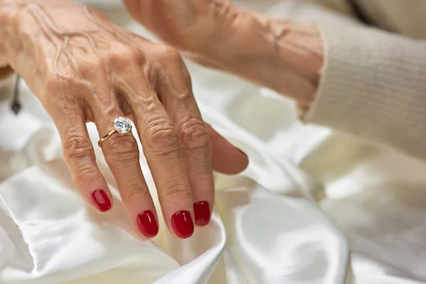 Женская рука в возрасте с бриллиантом . — стоковое фото
