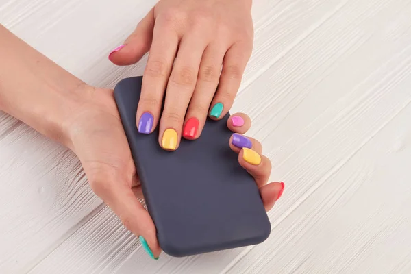 Kobiece kolorowy manicure i smartphone. — Zdjęcie stockowe