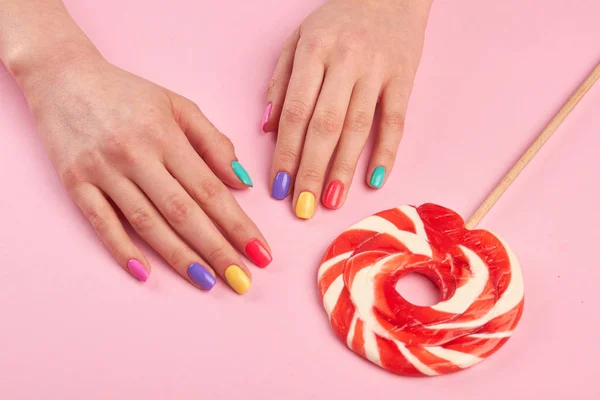 Female polished nails and lollipop. — Stock Photo, Image