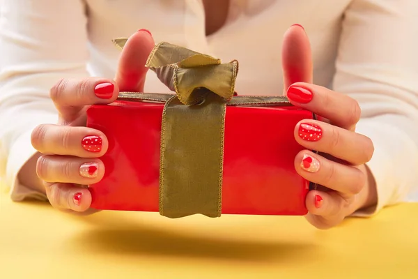 Красная подарочная коробка в женских маникюрных руках . — стоковое фото