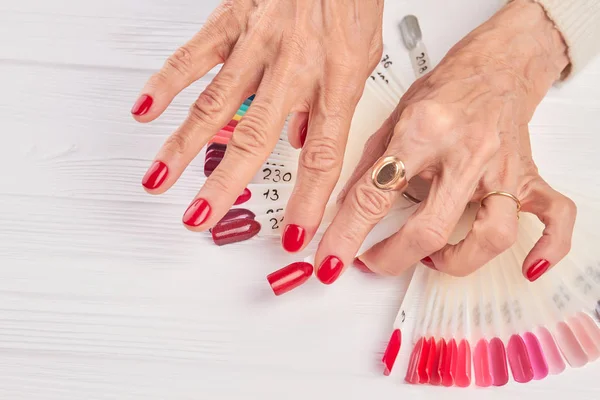 Esteticista aplicando verniz vermelho para unhas de mulher . fotos, imagens  de © Denisfilm #200364000