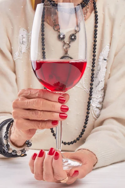 Large glass of wine in female hands. — Stock Photo, Image