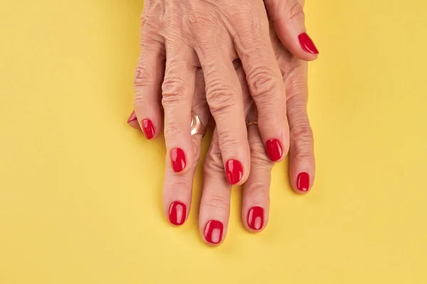 Mayores manos de mujer con manicura roja perfecta . — Foto de Stock