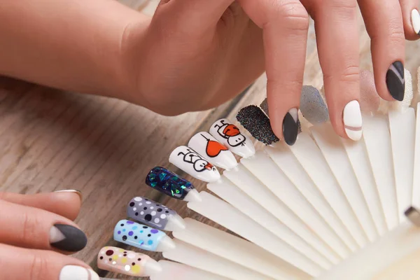 Vrouw handen selecteert nagels kunst design. — Stockfoto