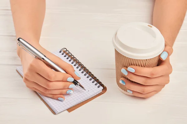 Mãos bem cuidadas segurando caneta e café . — Fotografia de Stock