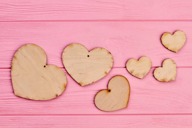 Sevgililer günü ahşap kalpler pembe bir arka plan üzerinde.