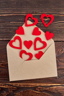 Açılan zarf ve kırmızı kağıt kalpler.
