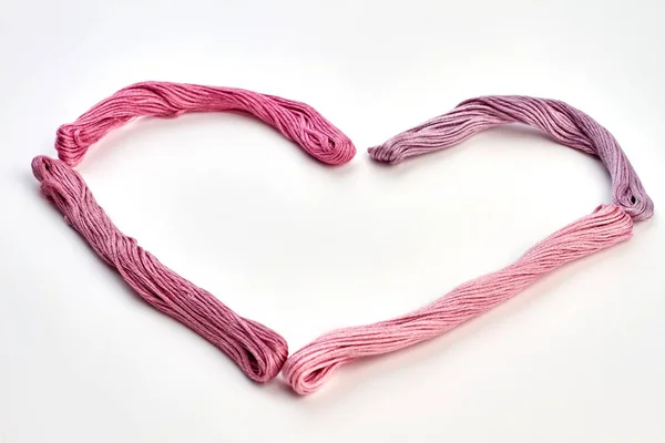 Форма сердца из разноцветных нитей вышивки . — стоковое фото