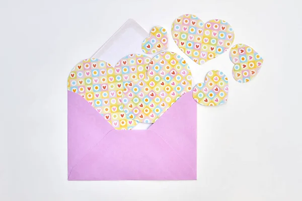 Opened envelope and collection of paper hearts. — Stock Photo, Image