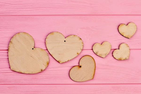 Valentijnsdag houten hart op roze achtergrond. — Stockfoto