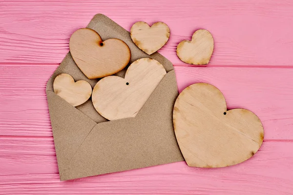 Kahverengi zarf ve kontrplak kalpler toplanması.