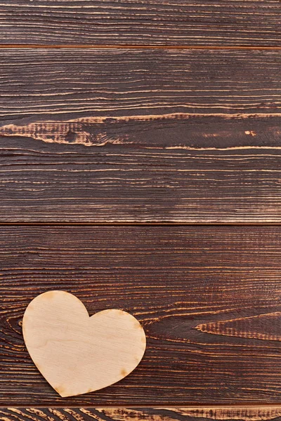 Corazón de madera contrachapada sobre fondo de madera marrón . — Foto de Stock