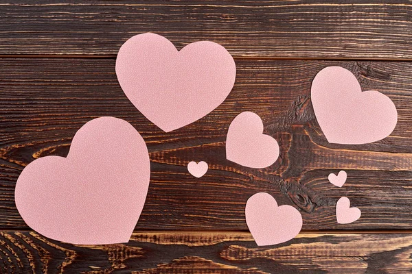 Corazones de papel sobre fondo de madera marrón . — Foto de Stock