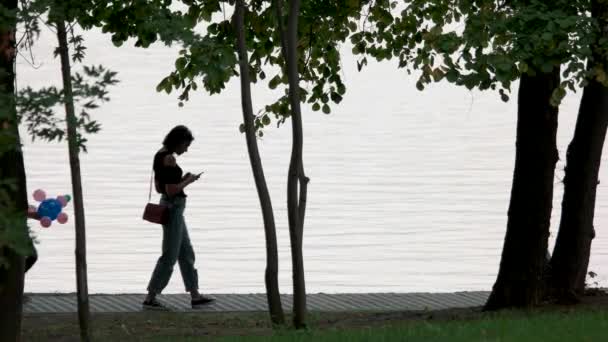 Paseando junto al lago del parque de la ciudad . — Vídeo de stock