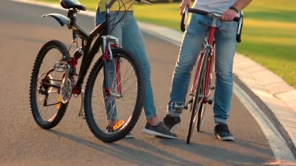 若いカップルの足で遊ぶ自転車. — ストック動画