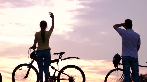 Jóvenes amigos con bicicletas al atardecer . — Vídeo de stock