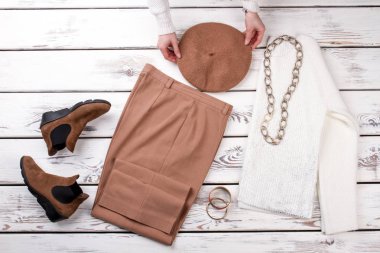 Eller masanın üzerinde kahverengi şapka koymak.