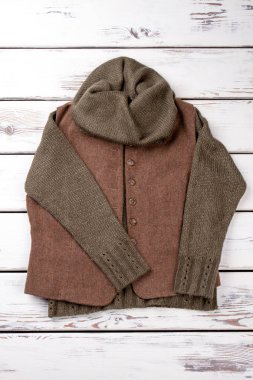 Düz için soğuk kış giyim sıcak yatıyordu. Parlak ahşap arka plan. Dikey görünüm.