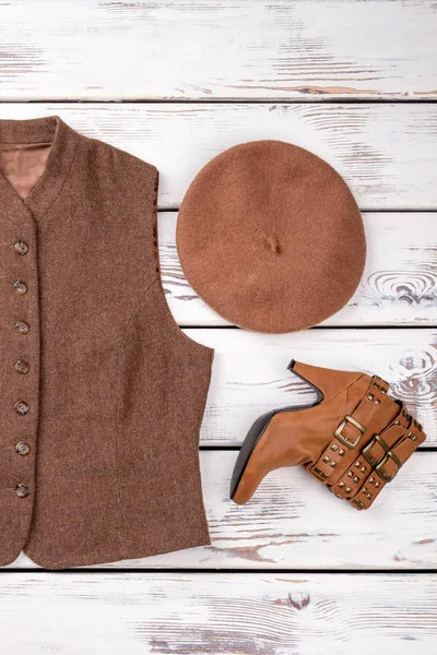 Kolsuz kadın yün ceket, şapka ve topuk çizme.