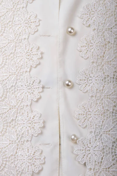 Close-up van glanzende knoppen op blanke vrouwen shirt. — Stockfoto