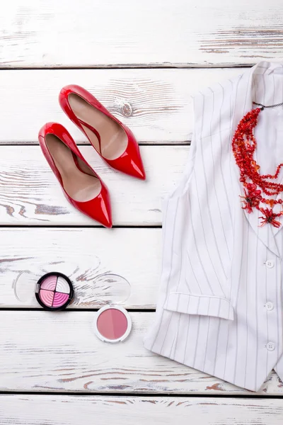 Zapatos rojos de tacón alto y polvo cosmético para maquillaje . — Foto de Stock